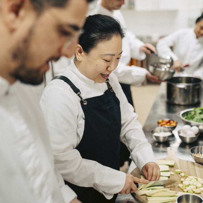 How food poisoning claims are investigated, chefs preparing ingredients in a commercial kitchen.