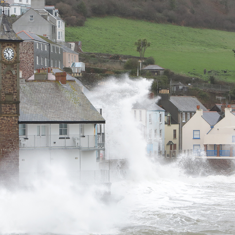 Water splashing on building by seashore