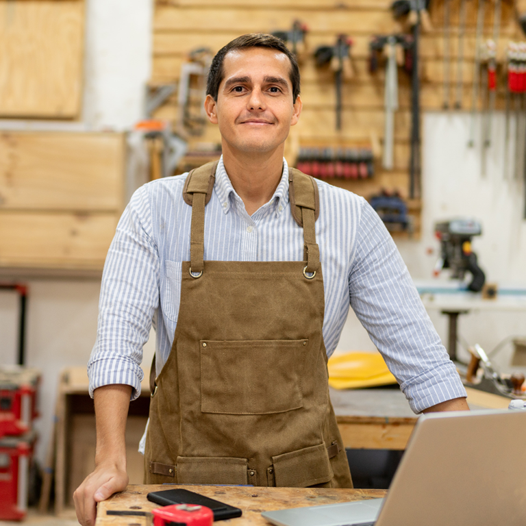 Man wearing an apron standing in a shop 